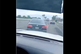 El conductor le pide a su hijo de 17 años de edad que grabe el vehículo de los ladrones, avanzando sobre la carretera.